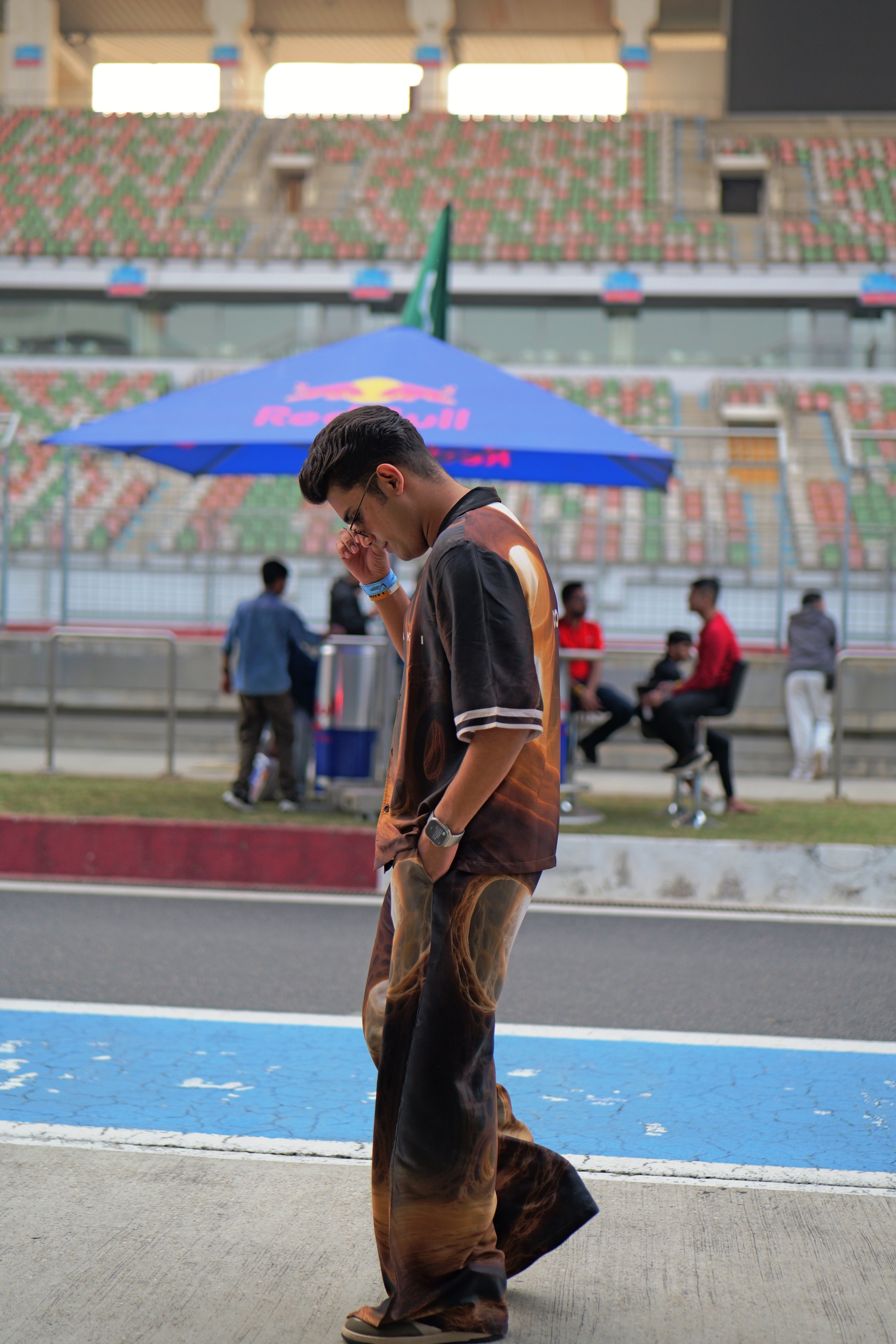 Man standing on a race track with a Red Bull branded umbrella in the background